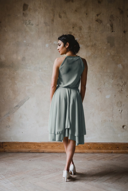 Kleid Tanzmarie in Dusty Mint von hinten mit locker fallendem Oberteil und zweilagigem, asymmetrischem Tellerrock